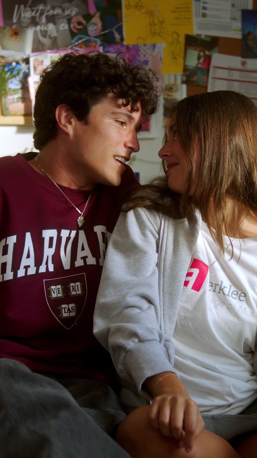 Strings Attached — a couple close together in Harvard and Berklee sweatshirts