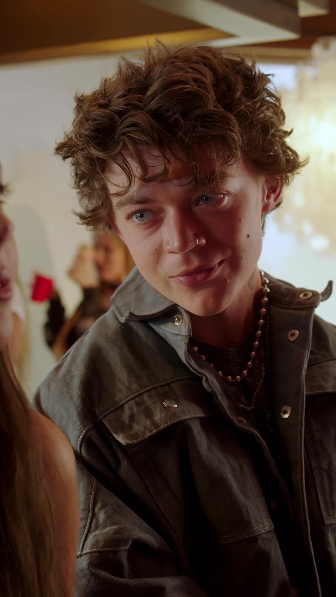 Strings Attached — a young man with curly hair at a party