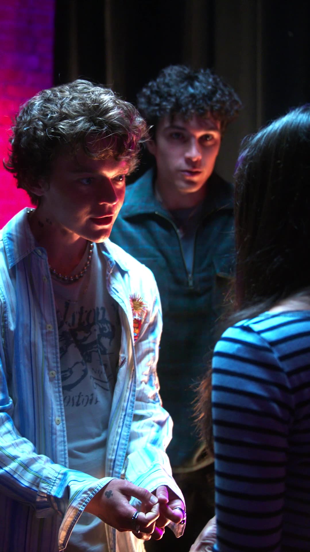 Strings Attached — three people in tense conversation at a dimly lit party